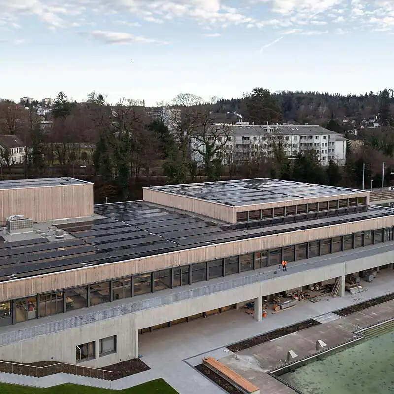 Luftaufnahme eines grossen Holzgebäudes mit Solarpanels auf dem Dach