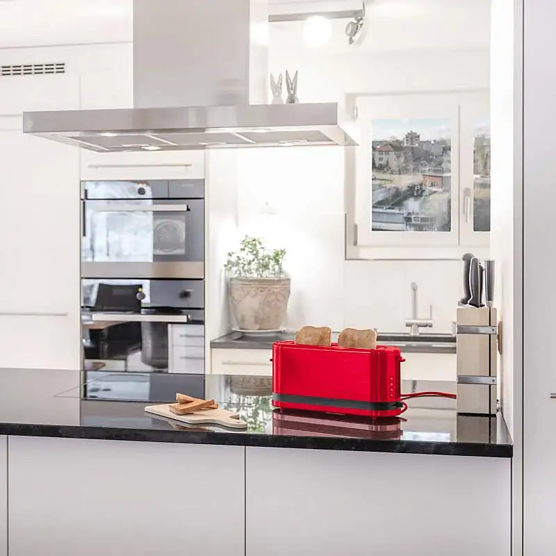Ein roter Toaster mit zwei Toasts steht auf einer Küchenablage